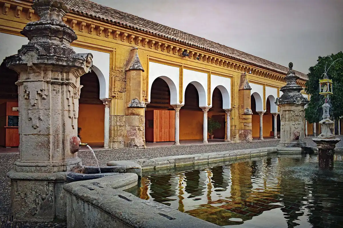 Rows of orange trees and a fountain in the Patio de los Naranjos beside the bell tower on a mosque cathedral of cordoba tour in Cordoba, Spain