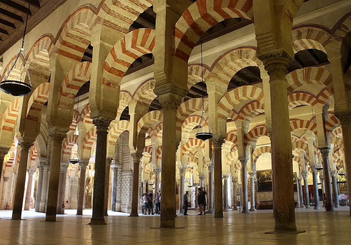 Endless rows of red-and-white double arches in the prayer hall on a mosque cathedral of cordoba tour in Cordoba, Spain