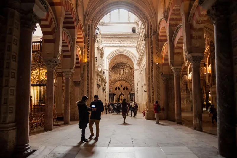 Striped arches receding through the columned hall on a great mosque of cordoba history tour in Córdoba, Spain