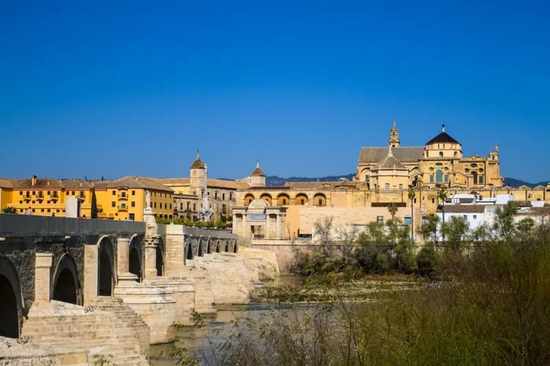 The Roman Bridge and Mosque-Cathedral skyline at dusk on a mosque jewish quarter and alcazar tour in Córdoba, Spain